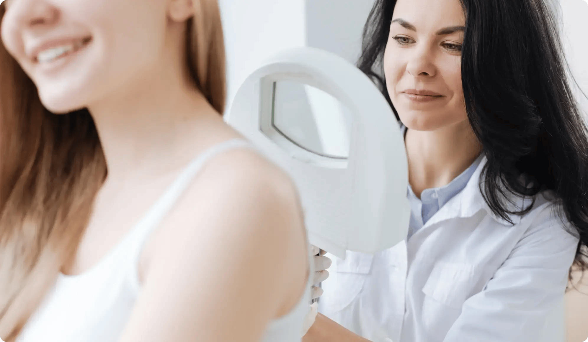 Smiling dermatologist inspecting a patient's back.